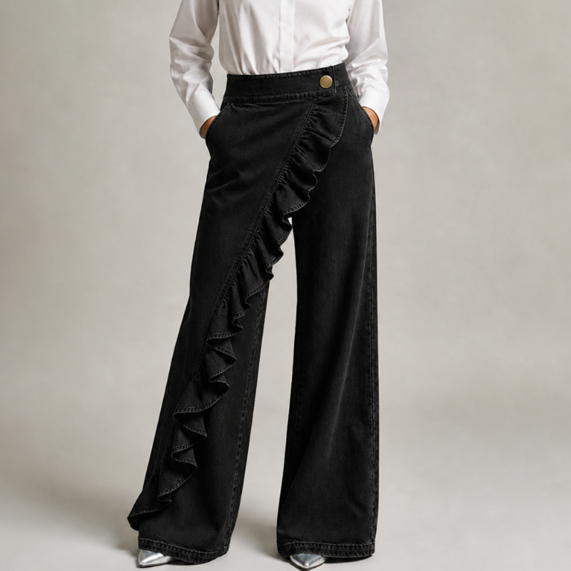 Front view of the black denim trousers with a white shirt, hands in pockets, showing the diagonal ruffle and gold button. 7