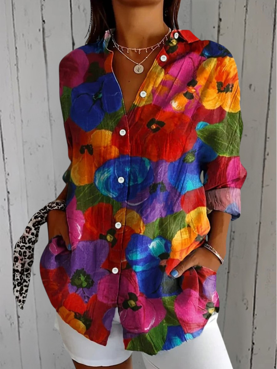 Model wearing the shirt covered in large poppy-like flowers in red, blue, orange and purple, with cuffs turned back. 6