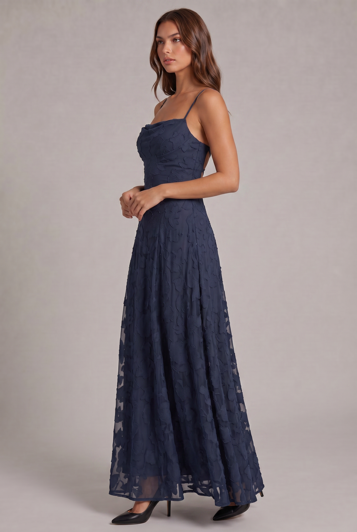 Side view of the navy blue maxi dress on a model, showing the fitted bodice and sheer, flowing floral skirt. 20