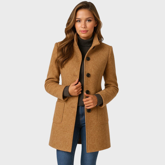 Model wearing the camel button-up coat open over a dark roll-neck jumper and jeans, hands resting at the front. 1