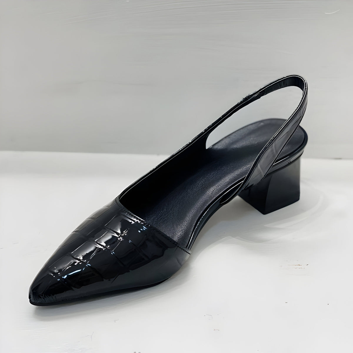 Black slingback heel seen from the other side on white, showing the cushioned insole, elasticated heel strap and block heel. 5