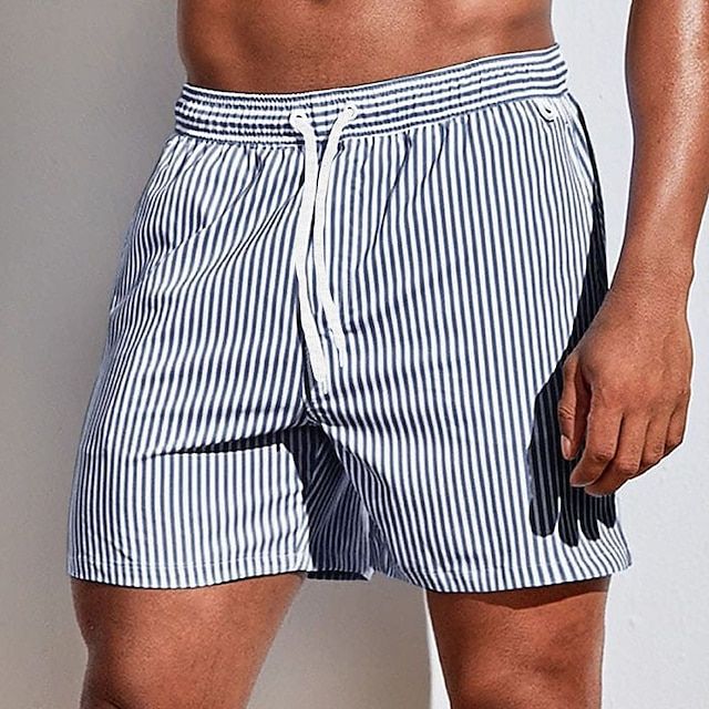 Model wearing navy and white vertically striped swim shorts with a white drawstring, shown from the front at thigh length. 13