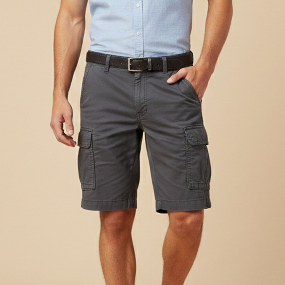 Man wearing dark grey cargo shorts with a light blue shirt and dark leather belt, one hand in his pocket. 12