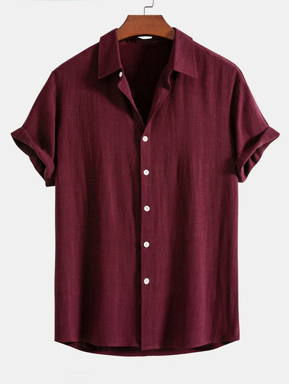 Burgundy short-sleeved shirt on a wooden hanger, front view with white buttons and turned-up sleeves. 7