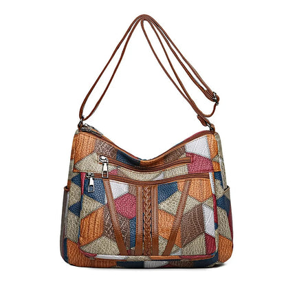 Front view of the bag on white, with two zipped pockets, braided brown trim and a long adjustable strap. 9