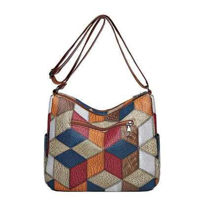 Back view of the bag on white, showing a large geometric patchwork design and a single zipped pocket. 10