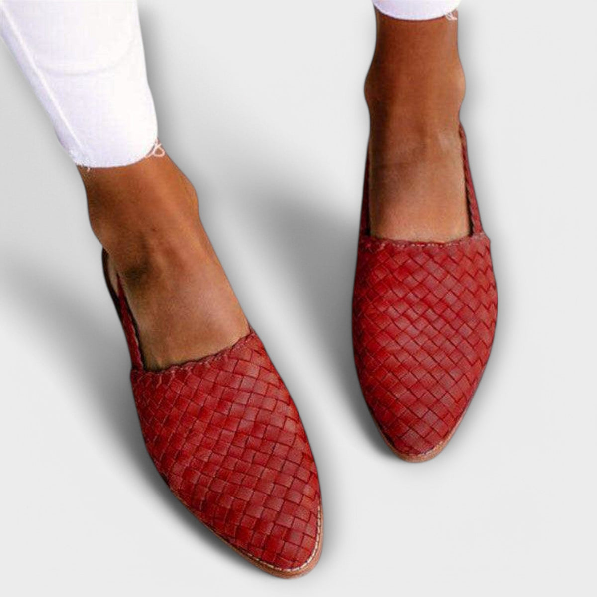 Red woven pointed-toe slip-ons worn with white frayed jeans, seen from above. 3