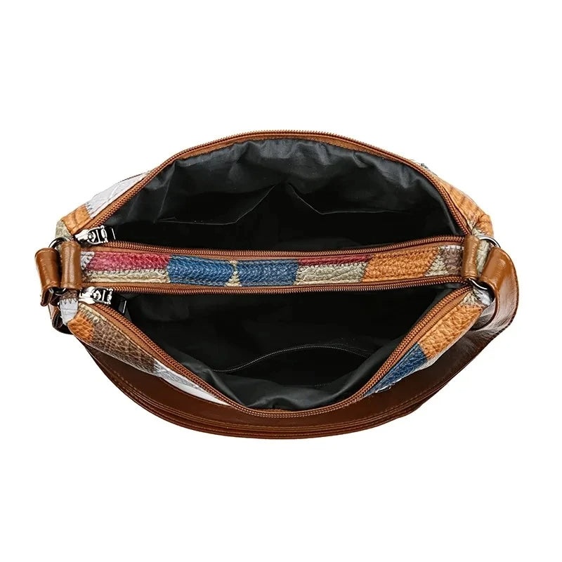 Top-down view of the open bag, showing the dark lining, the central zip divider and the patchwork-trimmed openings. 13