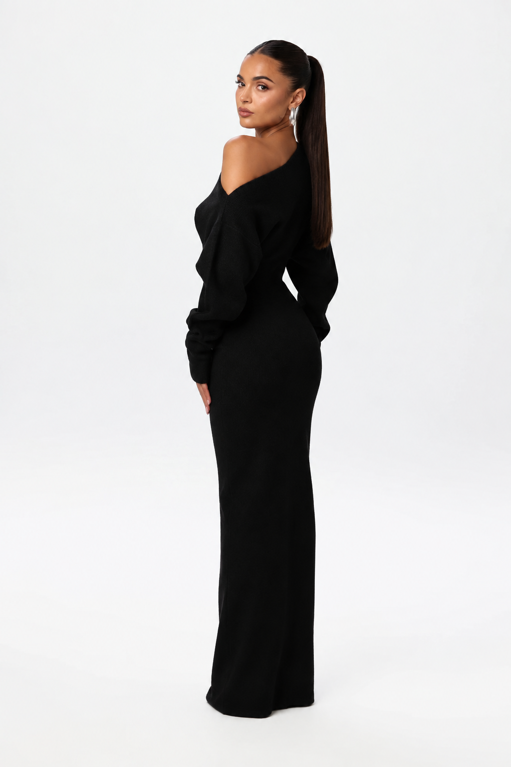 Model glancing over her shoulder in the black knit maxi dress, showing the back and sleeve shape. 4