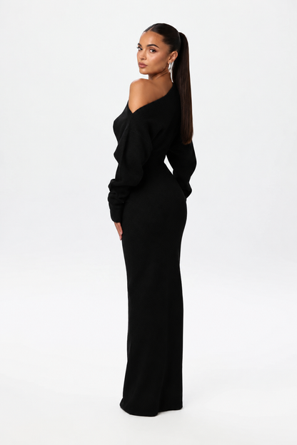 Model glancing over her shoulder in the black knit maxi dress, showing the back and sleeve shape. 4
