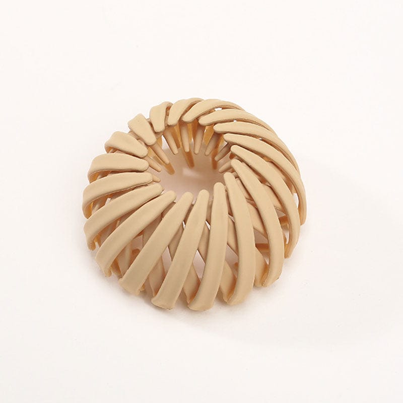 Single matte sand beige spiral bird's-nest clip on a plain pale background, showing its overlapping slats and open centre. 10