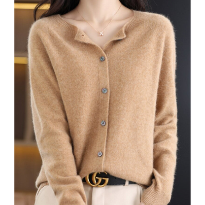Camel cardigan on a model with a dainty pendant necklace, collar slightly open, buttons fastened and a black belt at the waist. 11