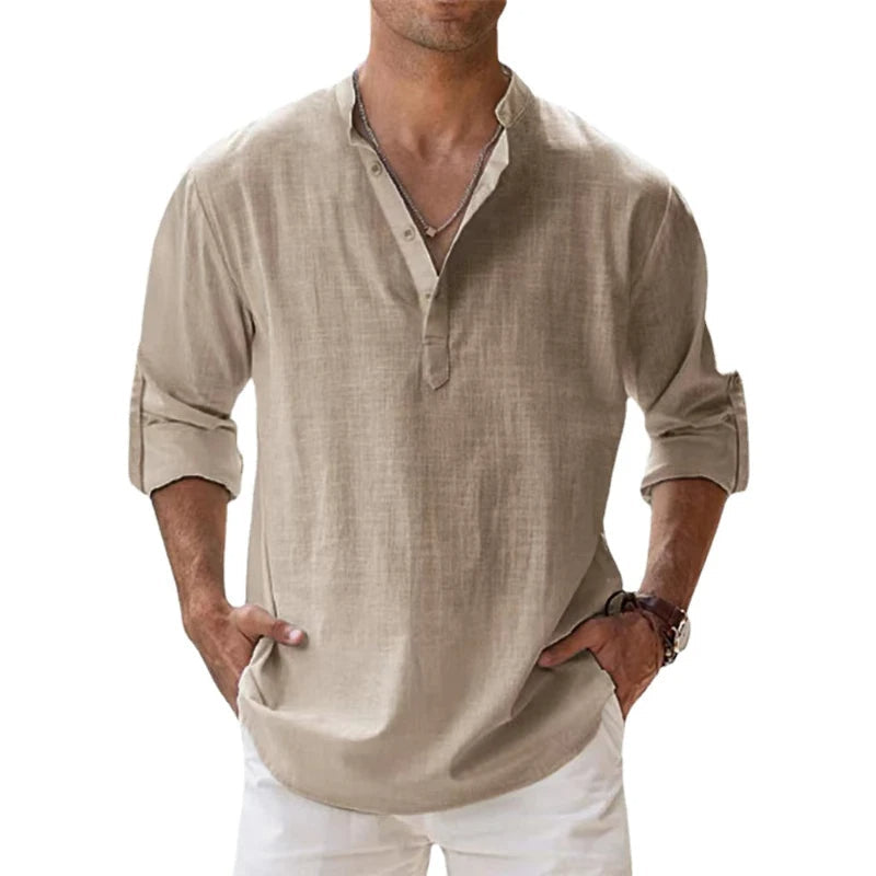 Model wearing the beige Henley shirt with sleeves rolled up and hands in the pockets of white trousers. 1