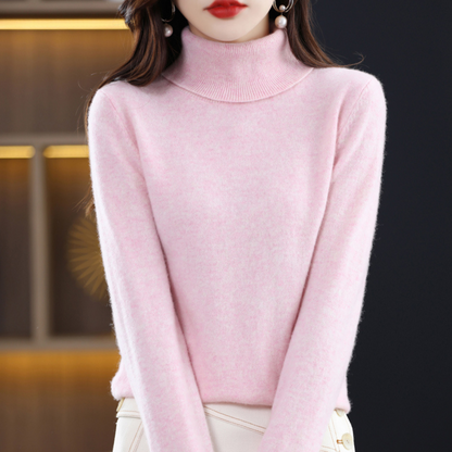 Model in the roll neck jumper in light blush pink, styled with a cream skirt with buttons. 8