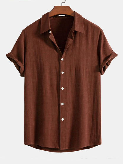 Rust brown short-sleeved shirt on a wooden hanger, front view with white buttons and cuffed sleeves. 1