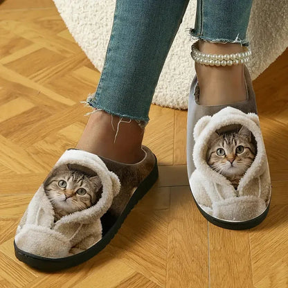 Slippers worn by a model on a parquet floor, showing the printed tabby cat in a fluffy hood on each toe. 3