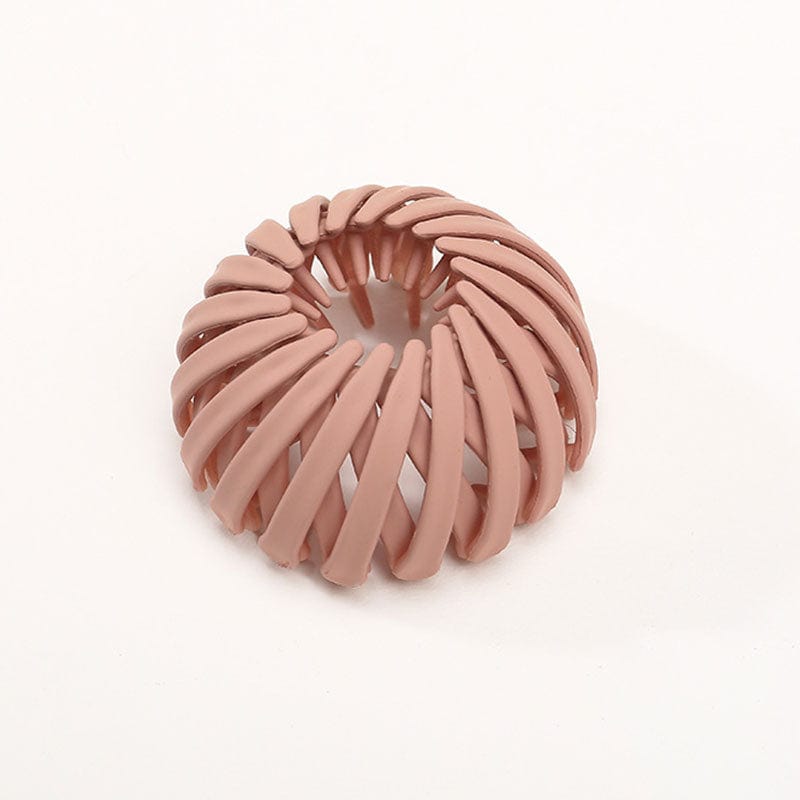 Single matte terracotta pink spiral bird's-nest clip on a plain pale background, with curved slats and inner prongs visible. 13