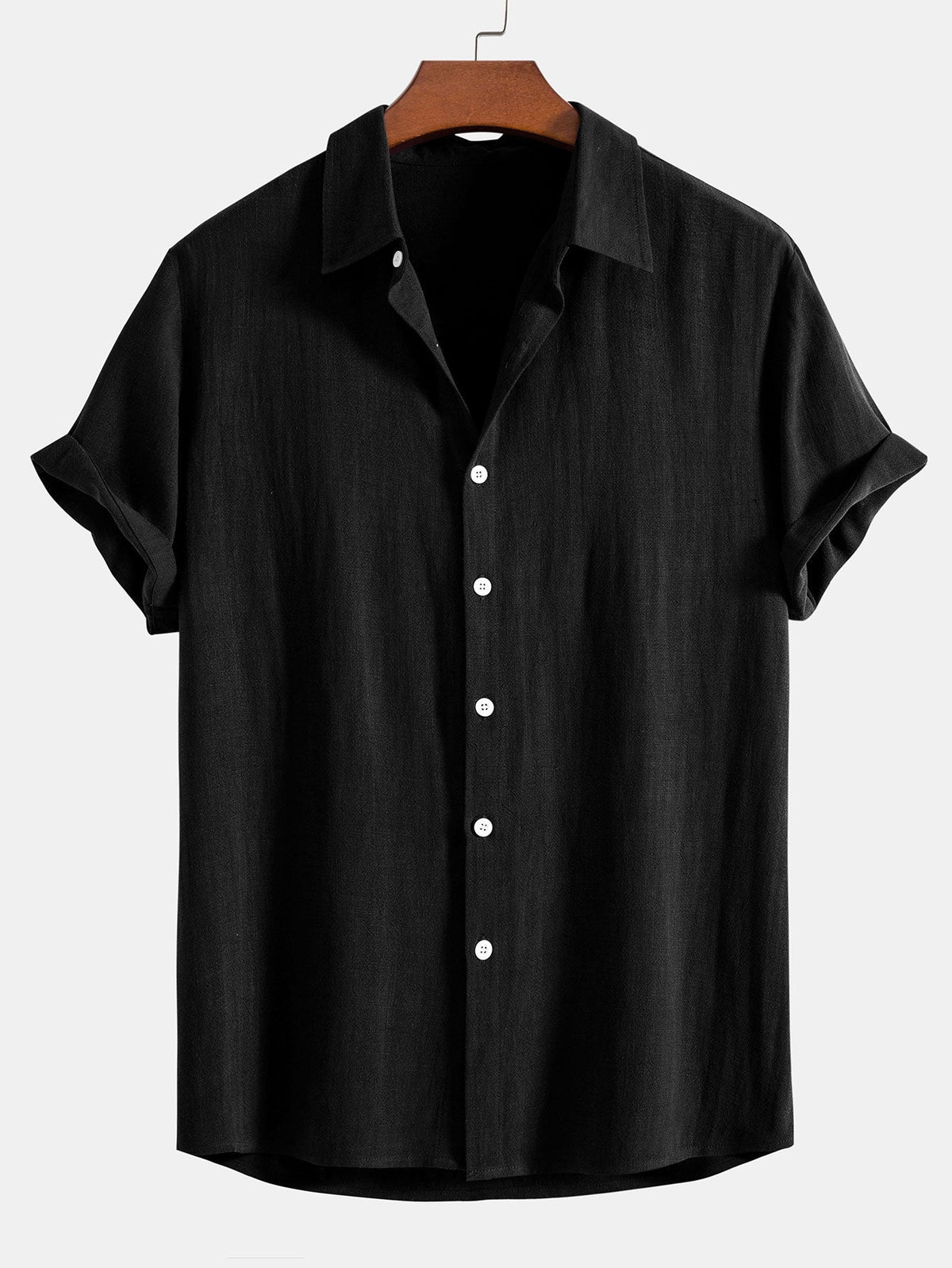 Black short-sleeved shirt on a wooden hanger, front view with white buttons and turned-up sleeve cuffs. 2