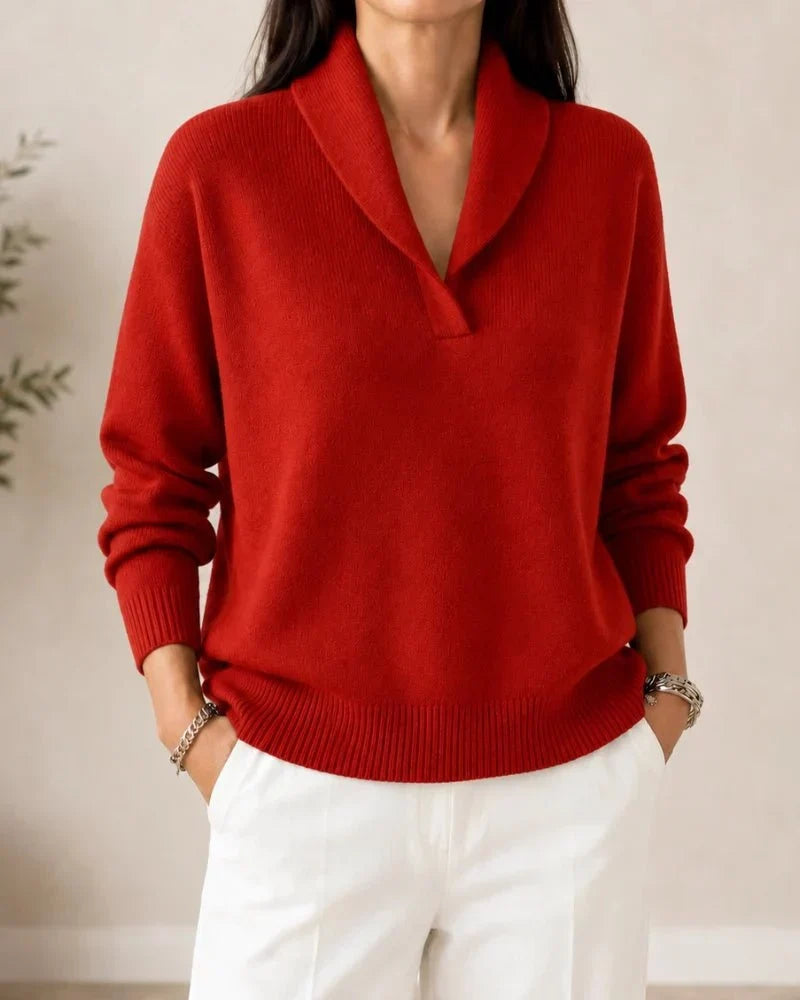 Front view of the jumper in bright red on a model wearing white trousers, showing the V-neck with shawl collar. 10