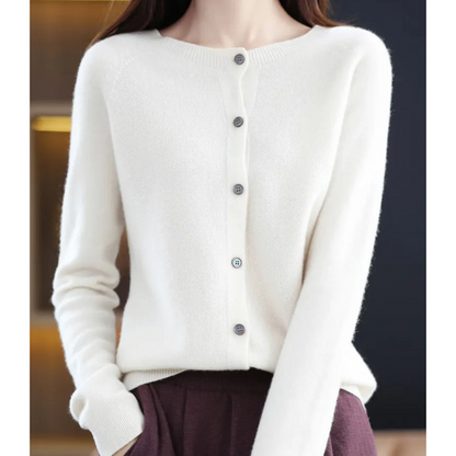 Cream-white cardigan on a model, fully buttoned with a ribbed round neck and raglan sleeves, styled with burgundy trousers. 5