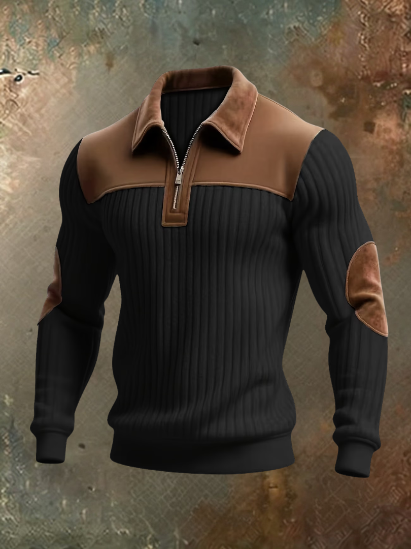 Black ribbed quarter-zip jumper with brown suede-look collar, shoulder yoke and elbow patches, shown front-on against a weathered backdrop. 3