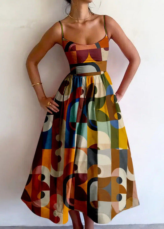 Model with hands on hips wearing a sleeveless midi dress with thin straps, fitted bodice and full gathered skirt in multicoloured geometric blocks. 1