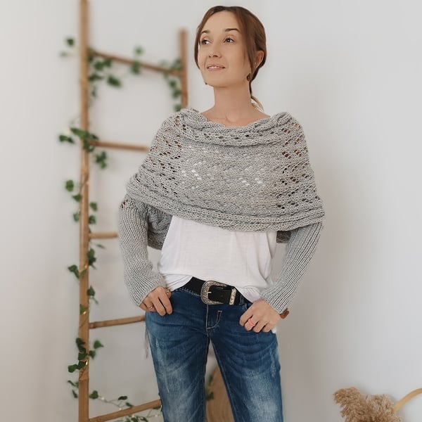 Light grey wrap with sleeves worn over a white top and belted jeans, model looking away and smiling. 8