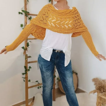 Model in a mustard-yellow version with arms stretched out, showing the lace-knit shoulder panel and ribbed sleeves over a white top and jeans. 22