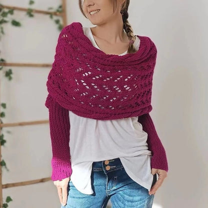 Model wearing the wrap in deep magenta, an open lace-knit cowl at the shoulders with ribbed sleeves, over a white top and jeans. 21