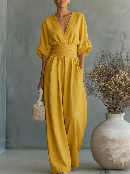 Same jumpsuit in mustard yellow, front view with a gathered high waistband and loose wide-leg trousers. 3