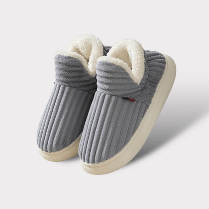 Pair of grey ribbed fleece-lined slippers with thick cream soles, shown on a plain light background. 20