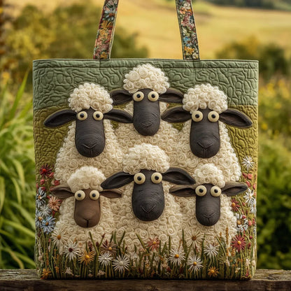 Quilted tote with six woolly sheep faces and wildflowers on a green field, floral straps, photographed on a wooden rail outdoors. 1