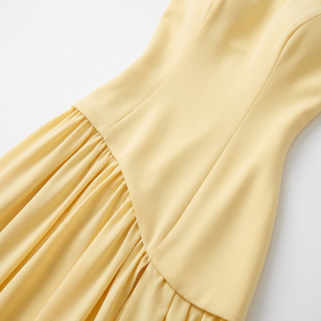 Close-up of the pale yellow dress bodice, showing the curved seam where the fitted top meets the gathered skirt. 5