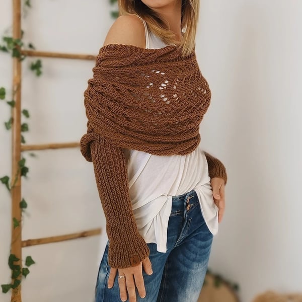 Rust-brown wrap worn off one shoulder, showing the ribbed sleeve and lace panel over a white top. 10
