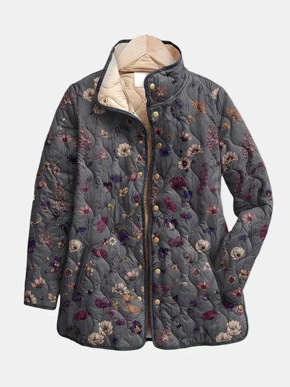 Grey quilted jacket with a purple and pink floral print, gold snap buttons and a cream lining, shown on a hanger. 2
