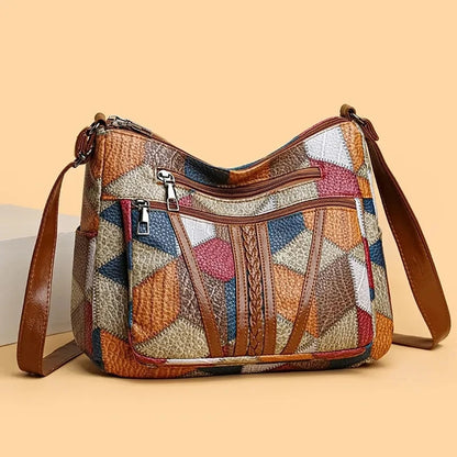 Front of the bag on a peach background, showing zipped pockets, braided brown strips and a side pocket. 5