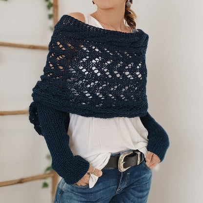 Deep navy lace-knit wrap worn off one shoulder with hands in pockets, paired with a white top and black belt. 16