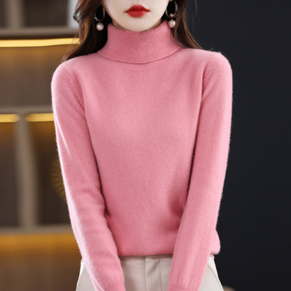 Model wearing the roll neck jumper in rose pink with hands lowered, paired with cream trousers. 7