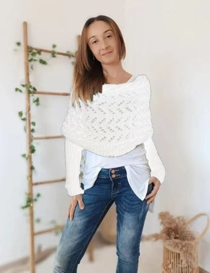 White lace-knit wrap with ribbed sleeves worn over a white top and jeans, model standing beside a ladder. 17
