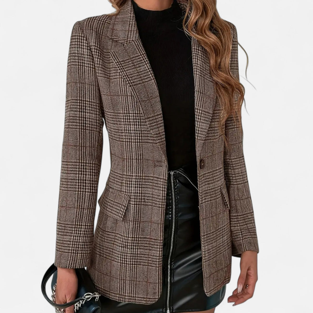 Close front view of the brown checked blazer worn open over a black top and black faux-leather skirt, showing lapels, flap pockets and one button. 1