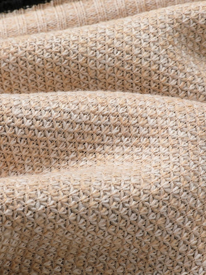 Close-up of the beige textured knit fabric, showing the small woven star-like stitch pattern in warm tones. 8