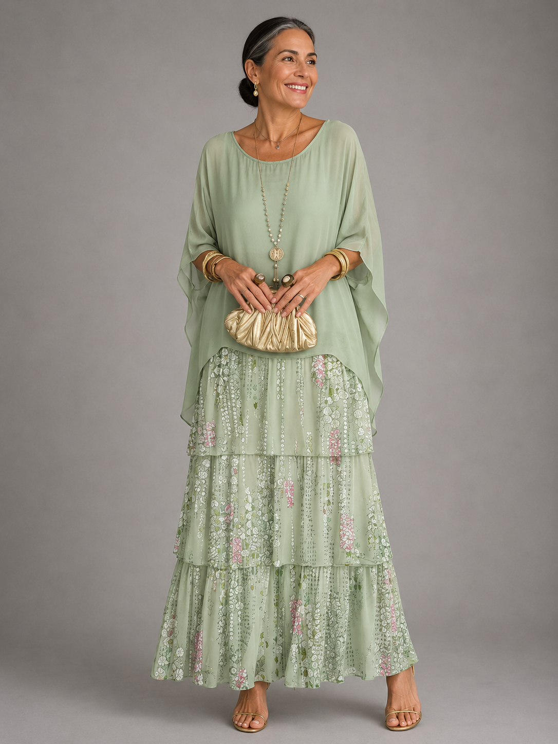 Woman in a pale mint green cape top over a tiered maxi skirt with a delicate pink and white floral print. 12