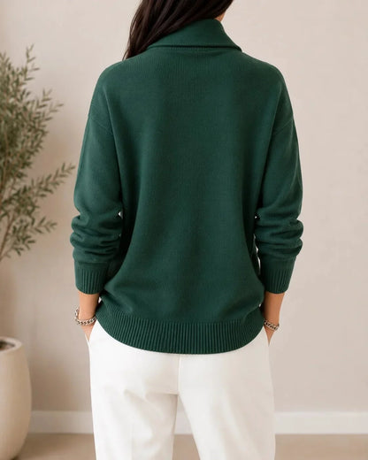 Back view of the dark green jumper on a model, showing the plain knit back, ribbed hem and cuffs, and the raised collar. 4