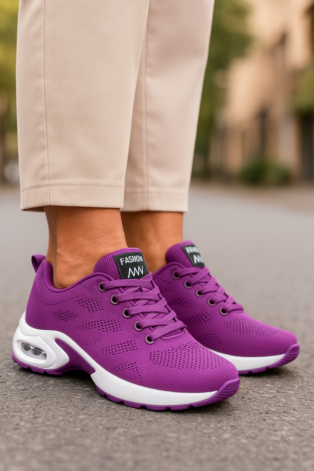 Purple knit trainers with white air-cushion soles and matching laces, worn with beige trousers on tarmac. 7