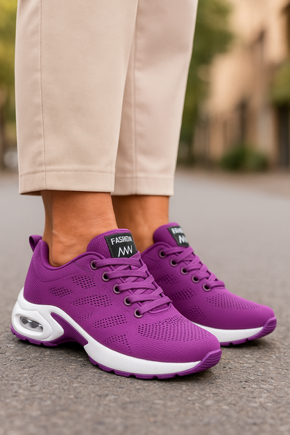 Purple knit trainers with white air-cushion soles and matching laces, worn with beige trousers on tarmac. 7