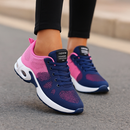 Navy and pink two-tone knit trainers with white air-cushion soles, worn with black leggings on a road. 5