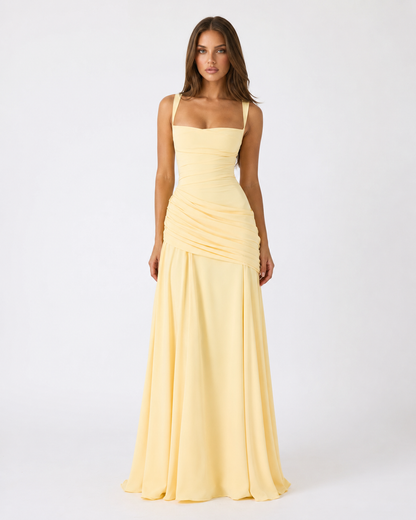 Full-length front view of the pale yellow maxi dress on a model, showing wide straps and diagonal gathered waist. 4