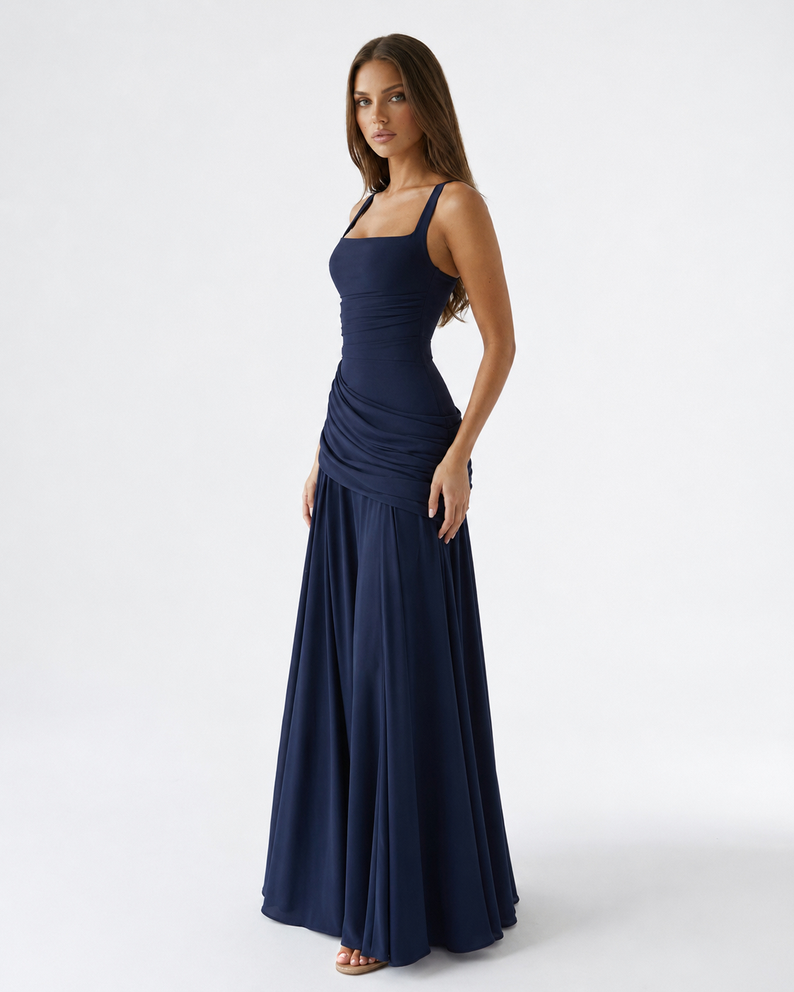 Navy blue dress on a model, three-quarter view showing the square neckline and draped hip. 6