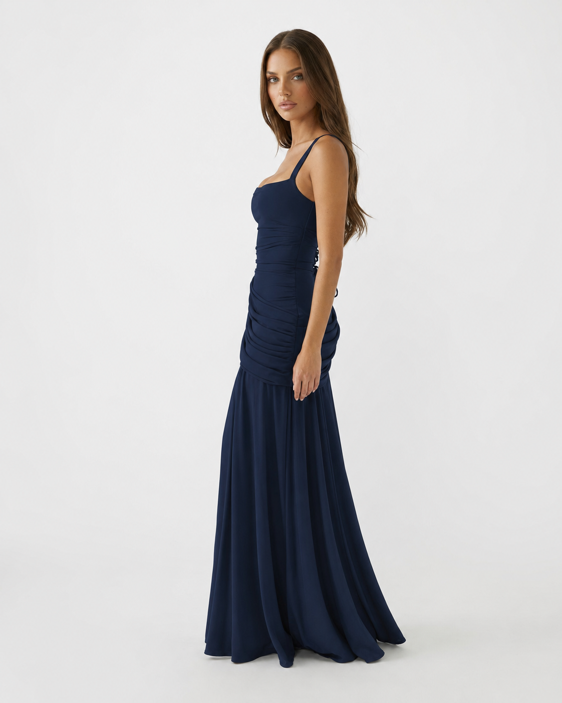 Side view of the navy dress with thin straps, gathered hip draping and full flowing skirt. 7