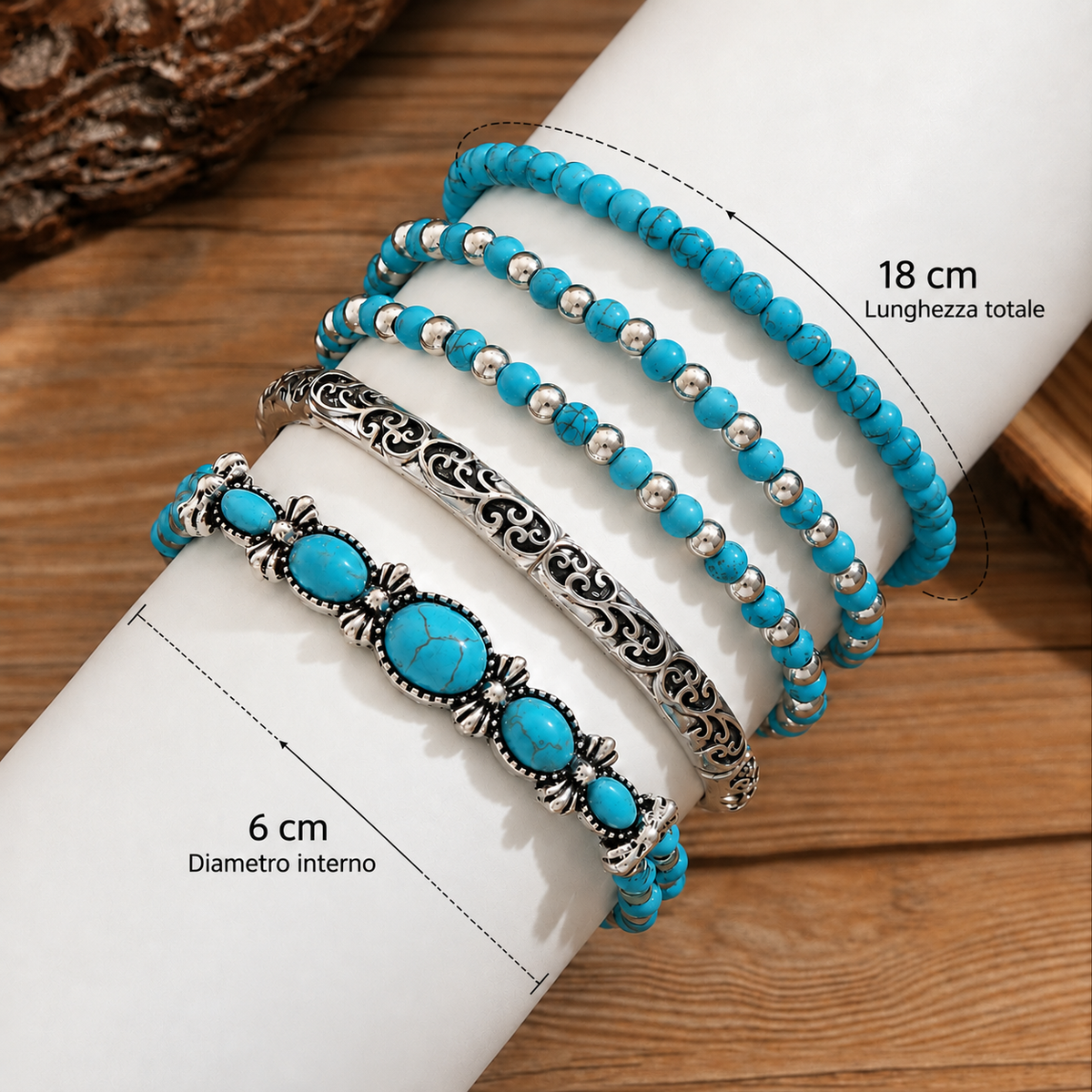 The five bracelets laid over a white tube on wood, with measurement lines marking the overall length and inner diameter. 4